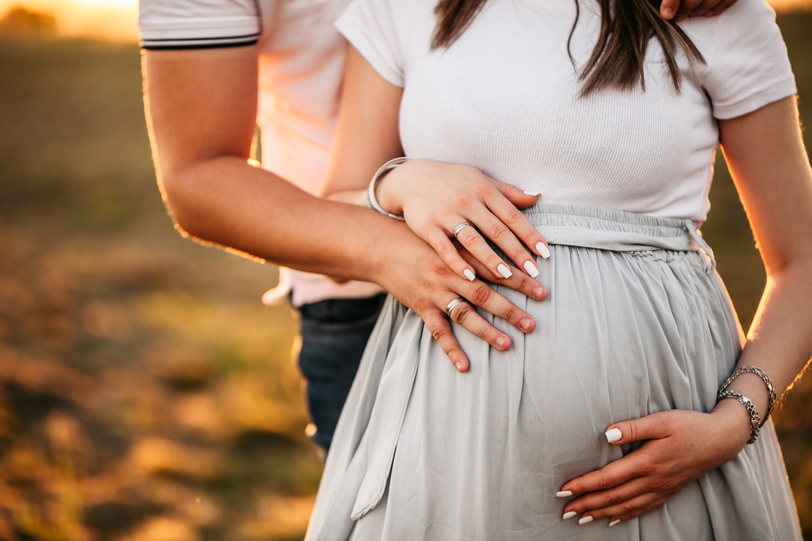 Pregnant happy couple at sunset